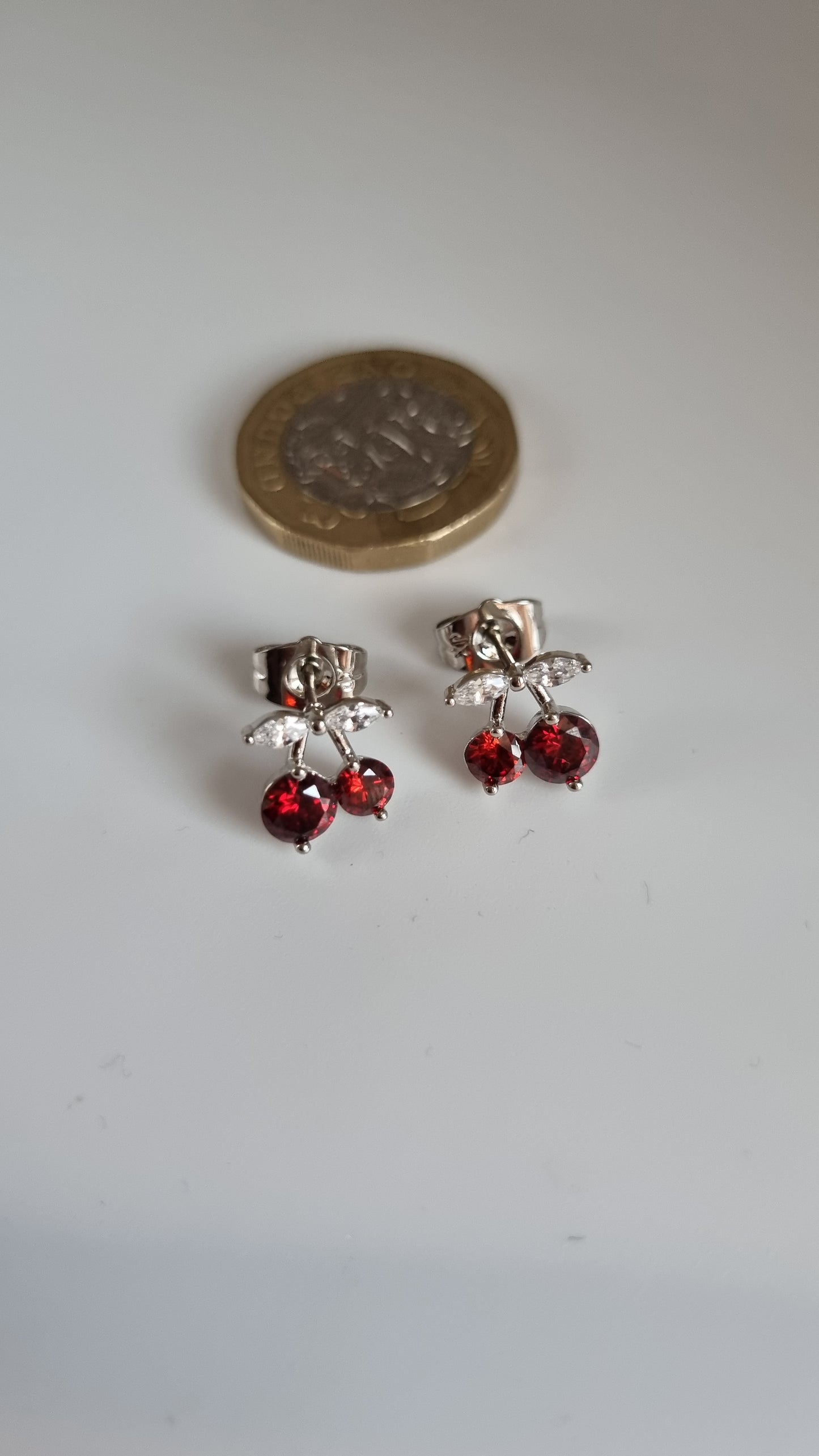 Platinum plated stud earrings with granet color zircon stone and white